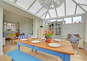 a dining room with a blue table and chairs at Crows Nest in Brancaster