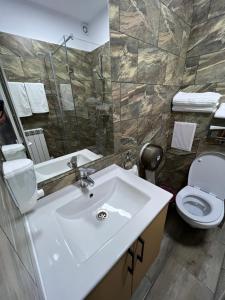 a bathroom with a sink and a toilet at Stef Rooms in Tîrgu Frumos