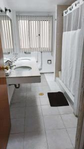 y baño blanco con lavabo y ducha. en Steinhaus Suites Hamburgo, en Ciudad de México