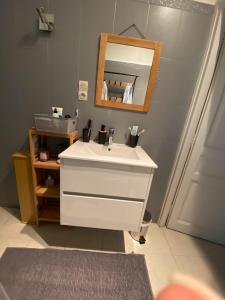 La salle de bains est pourvue d'un lavabo blanc et d'un miroir. dans l'établissement Ajaccio, Appt, lumineux, proche centre Ville, à Ajaccio