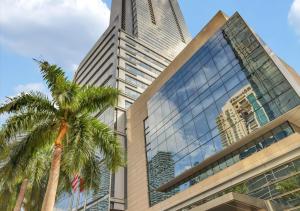 a tall building with a palm tree in front of it at Amazing studio in Four Seasons Residences Brickell! in Miami