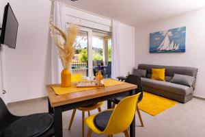 a living room with a table and chairs and a couch at Arba sunshine in Rab