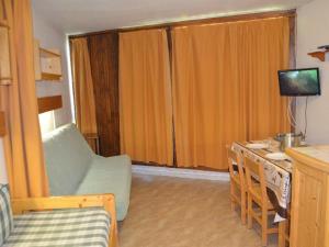 a room with a bed and a desk with a television at Studio Les Menuires, 1 pièce, 3 personnes - FR-1-452-191 in Les Menuires