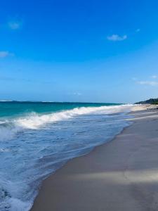 una spiaggia con l'oceano e le onde di Tiwi Tatu a Tiwi