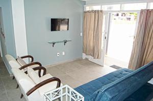 a living room with a blue couch and chairs at Casa com 2 quartos à 200 m da da praia c/ churrasqueira in Palhoça