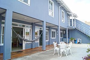 un edificio azul con una mesa y sillas delante de él en Casa com 2 quartos à 200 m da da praia c/ churrasqueira en Palhoça