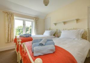 a bedroom with two beds with towels on them at The Cottage in Hickling