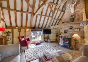 a living room with a fireplace and a wooden ceiling at Apple Tree Cottage in Poringland