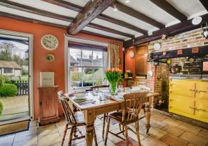a dining room with a wooden table and chairs at Apple Tree Cottage in Poringland