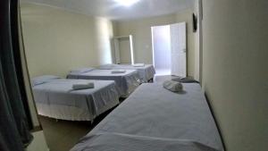 a room with four beds in a room at Hotel Aracaju Express in Aracaju