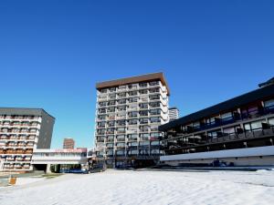 um edifício de apartamentos alto com uma praia em frente em Studio Les Menuires, 1 pièce, 2 personnes - FR-1-452-264 em Les Menuires
