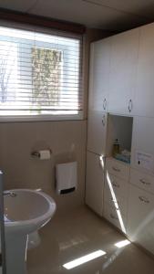 a white bathroom with a sink and a window at Appartement Bellevue in Saint-Félicien