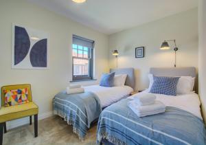- une chambre avec deux lits, une chaise et une fenêtre dans l'établissement Samphire Cottage, à Mundesley