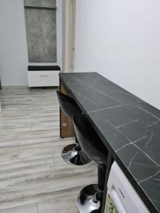 a black counter top in a kitchen with a floor at Bucovina Cazare in Câmpulung Moldovenesc +3 photos