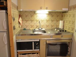 eine Küche mit einer Spüle und einer Mikrowelle in der Unterkunft Studio Les Menuires, 1 pièce, 2 personnes - FR-1-452-283 in Les Menuires