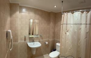 y baño con lavabo, aseo y ducha. en Guesthouse Hitar Petar en Gabrovo
