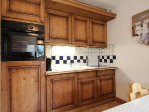 a kitchen with wooden cabinets and a sink at Appartement Les Carroz d'Arâches, 4 pièces, 6 personnes - FR-1-572-36 in Arâches-la-Frasse
