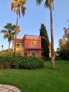 uma casa com palmeiras e um jardim verde em isla canela golf em Isla Canela