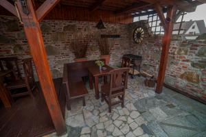 a dining room with a table and chairs and a clock at Apartamenty przy górskich rzekach in Nowy Targ