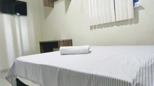 a white bed with a towel on top of it at Hotel Aracaju Express in Aracaju
