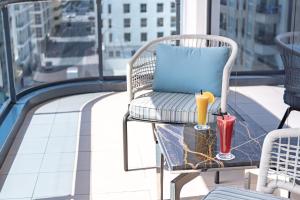 una sedia con cuscino e un drink sul tavolo sul balcone di Golden Sands Hotel Apartments a Dubai