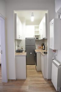 a kitchen with white cabinets and a gray refrigerator at Stan Na Dan Central Park in Raška