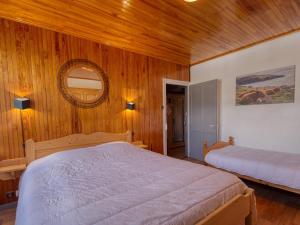 1 dormitorio con 2 camas, espejo y paredes de madera en Maison Morillon Village, 3 pièces, 7 personnes - FR-1-642-16 en Morillon