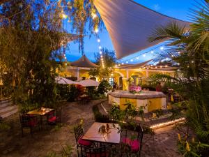 un restaurante al aire libre con mesas y sillas por la noche en Hotel Convento Santa Catalina by AHS, en Antigua Guatemala