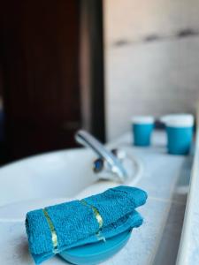 un asciugamano blu su un piatto su un lavandino del bagno di Tiwi Tatu a Tiwi