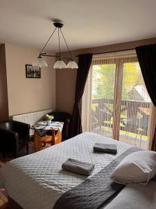 sypialnia z dużym łóżkiem i dużym oknem w obiekcie Klimkowa Chata w Zakopanem