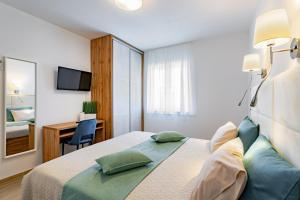 una camera d'albergo con letto e scrivania di Arba sunshine a Rab