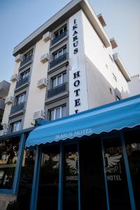 um hotel com um toldo azul em frente em ikarushotel em Aidim
