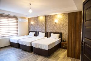 um quarto com 2 camas e lençóis brancos em ikarushotel em Aidim