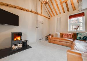 a living room with a couch and a fireplace at The Wedge in Little Walsingham