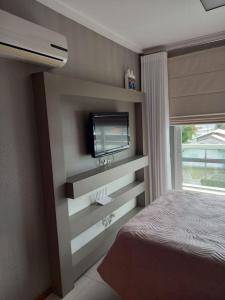 1 dormitorio con 1 cama y TV en la pared en Nautilus Concept - Penha/SC, en Penha