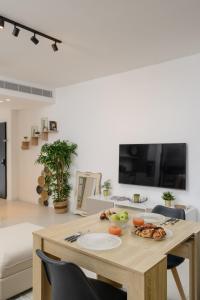 a table with a plate of food on it in a living room at The Unexpected by HolyGuest in Tel Aviv