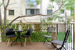 a group of chairs and a table on a deck at The Unexpected by HolyGuest in Tel Aviv