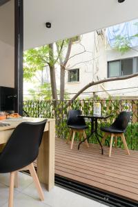 a wooden deck with chairs and a table on it at The Unexpected by HolyGuest in Tel Aviv