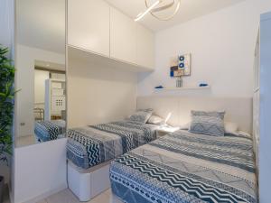 ein kleines Schlafzimmer mit 2 Betten und einem Spiegel in der Unterkunft Casa Blanca Las Canteras in Las Palmas de Gran Canaria