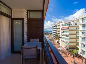 einen Balkon mit einem Tisch, Stühlen und Gebäuden in der Unterkunft Casa Blanca Las Canteras in Las Palmas de Gran Canaria