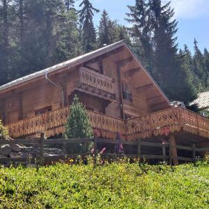 uma grande casa de madeira com uma grande varanda em Appartement dans Chalet Lout'Chi à Valfréjus em Valfréjus