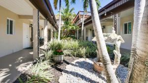 um alpendre de uma casa com palmeiras e plantas em Palm Crest Resort Motel em St. Pete Beach