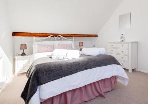 a bedroom with a large bed with white furniture at Quebec in Cromer