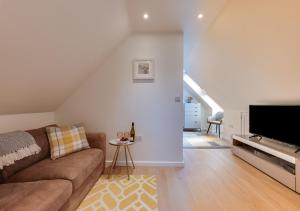 a living room with a couch and a flat screen tv at Beech Corner in Cawston