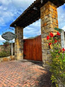 eine steinerne Einfahrt mit einem Holzzaun und einem Tor in der Unterkunft Hotel Campestre Franchesca in Tabio