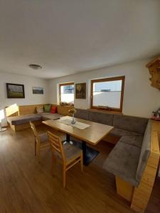 ein Wohnzimmer mit einem Tisch und einem Sofa in der Unterkunft Großzügiges Apartment Georg Mayrhofen Barrierefrei in Hollenzen