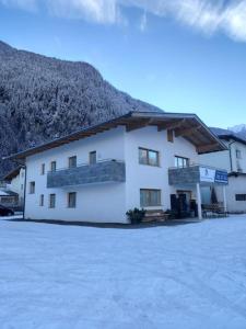 ein großes weißes Gebäude mit einem Berg im Hintergrund in der Unterkunft Großzügiges Apartment Georg Mayrhofen Barrierefrei in Hollenzen