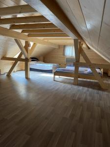 a attic room with two beds and a wooden floor at Drevenice Horné Kysuce in Vysoká nad Kysucou