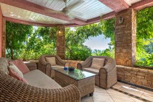 an outdoor patio with wicker chairs and a table at Maria Elena Villas I in Lagomandra