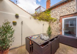 a patio with a table with cups on it at Eva Cottage in West Runton